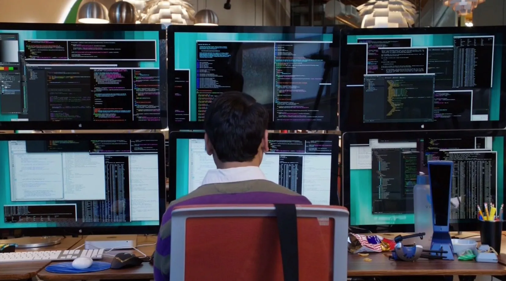 Post cover: Kumail Nanjiani as Dinesh Chugtai in Silicon Valley (2014–2019) is working with six monitors arranged in two rows.